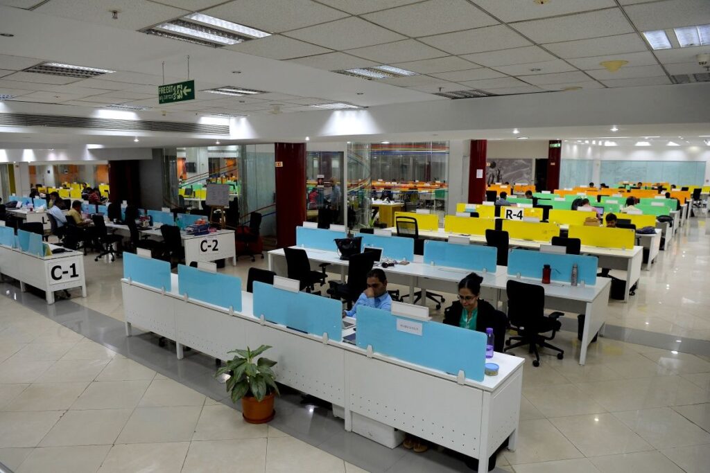 people working in cubicle office in multinational company